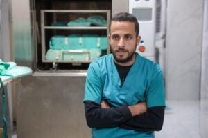 Doctor in scrubs sitting with arms crossed