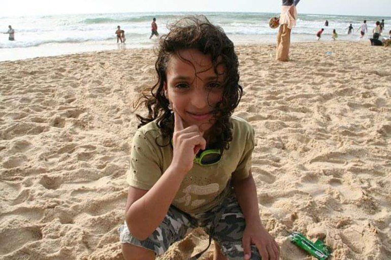 Young woman in cap and gown on a football pitch