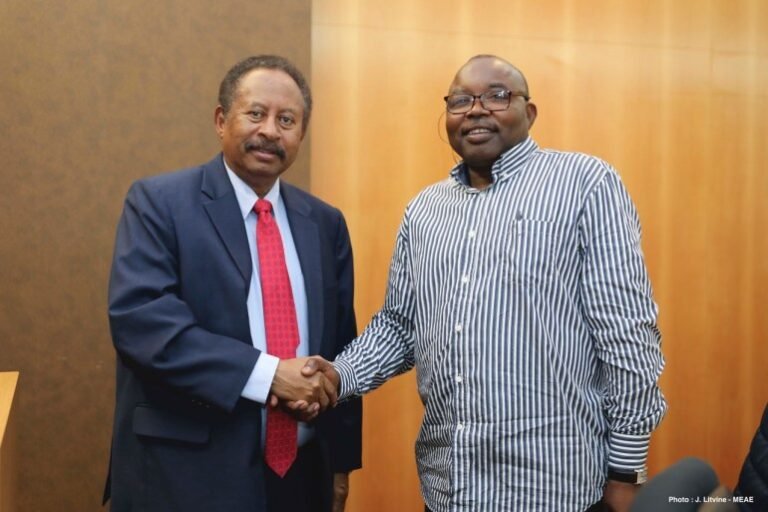 Abdallah Hamdok on the left in a suit and Abdel Wahid Nur on the right in a striped shirt