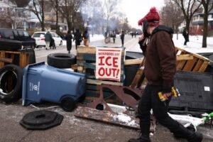 Demonstrators gather at the street where 37-year-old Renee Nicole Good was shot and killed at point blank range on January 7 by a US Immigration and Customs Enforcement (ICE) agent as she apparently tried to drive away from agents who were crowding around her car, in Minneapolis, Minnesota, on January 8, 2026.