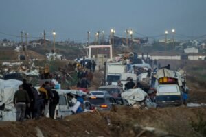 improvised lights surround cars driving through piles of dirt near a checkpoint