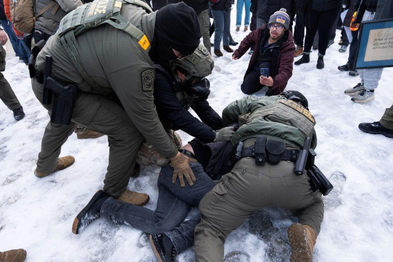 Federal agents tackle a protester to the ground before detaining him outside of the Whipple Federal Building as immigration enforcement action continues, following the fatal shooting of Renee Nicole Good by a U.S. Immigration and Customs Enforcement (ICE) agent, in Minneapolis, Minnesota, U.S., January 8, 2026. REUTERS/Tim Evans