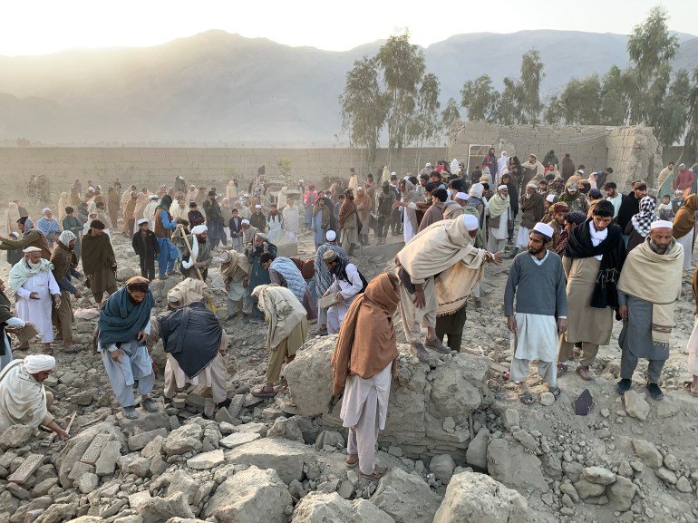 Afghan men search for victims after an overnight Pakistani airstrike hit a residential area in the Girdi Kas village
