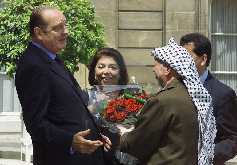 (FILES) Palestinian Authority President Yasser Arafat (R), next to Palestine's general delegate in France, Leila Shahid (C), offers flowers to French President Jacques Chirac on July1, 2000 at his arrival at the Elysee Palace in Paris.