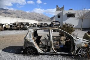 A man stands beside burnt vehicles inside a torched police station on the outskirts of Quetta on February 1, 2026 a day after an attack by Baloch separatists.Pakistan forces were hunting on February 1 for the separatists behind a string of coordinated attacks in the restive Balochistan province, with the government vowing to retaliate after more than 190 people were killed in two days.