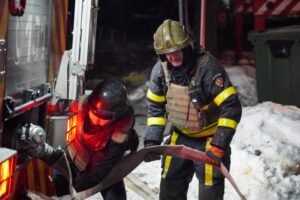 Ukrainian emergency workers are seen at the site of an apartment building that was damaged following a Russian air attack in Kyiv