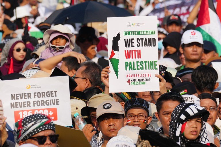 Protesters hold up posters during a rally in solidarity of the Palestinians in Gaza, in Jakarta, Indonesia, Sunday, Oct. 12, 2025. (AP Photo/Tatan Syuflana)