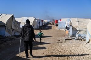 AL HASAKAH, SYRIA - JANUARY 26: Detainees are seen between tents at the al-Hol camp on January 26, 2026 in Al Hasakah, Syria. The al-Hol camp (also spelled Al-Hawl) in Syria's northeastern Hasakah province has come under control by Syrian government forces, following the withdrawal of the Kurdish-led Syrian Democratic Forces (SDF) in recent days. The camp houses around 24,000 people, many of whom are women and children, with alleged links to the jihadist group Islamic State (IS), also referred to as ISIS in the region. Clashes between the SDF and government forces this month over the former's integration with state institutions has seen large swaths of Kurdish-controlled territory ceded. Under a ceasefire agreement, camps and prisons housing ISIS detainees previously held by the US-backed Kurdish forces are to be transferred to the government. The United Nations (UN) has said it will take over management of al-Hol, resuming the delivery of humanitarian supplies to the camp, amid dire conditions. (Photo by Abdulmonam Eassa/Getty Images)