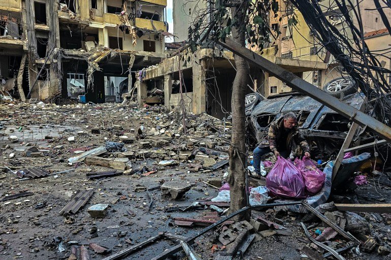 A man removes items in plastic bags at the site of overnight Israeli airstrikes in the southern suburbs of Beirut on March 16, 2026.
