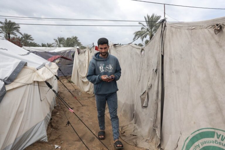 Abdel Karim Salman heads daily to the charging station to charge his phone and his wife&rsquo;s phone, which they use as a source of light in their tent throughout the night [Abdelhakim Abu Riash/ Al Jazeera]