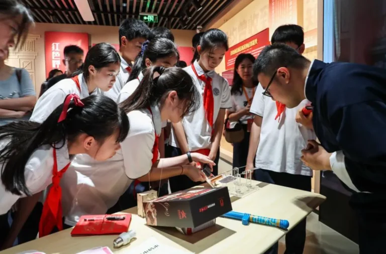 Alunos de uma escola secundária local realizam um curso de estudo no local de uma exposição que comemora a inauguração das comunicações por rádio e código do Partido Comunista da China em Xangai, leste da China, a 2 de junho de 2026. (Xinhua/Shan Yuqi)