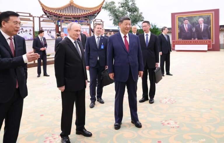 O presidente chinês Xi Jinping e o presidente russo Vladimir Putin visitam uma exposição fotográfica que celebra a amizade eterna entre os dois países no Grande Salão do Povo, em Pequim, capital da China, em 20 de maio de 2026. (Xinhua/Huang Jingwen)